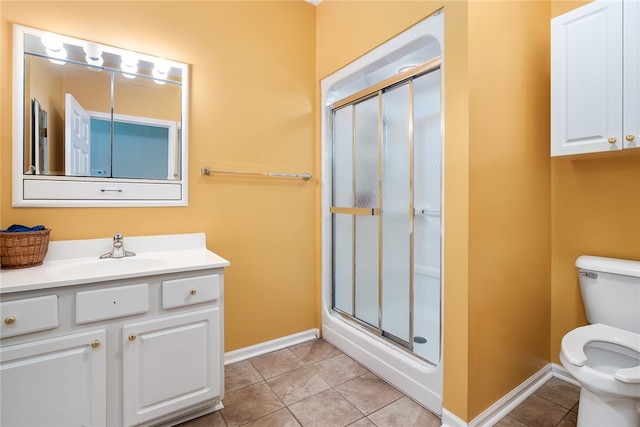 bathroom with tile patterned floors, a shower with door, vanity, and toilet