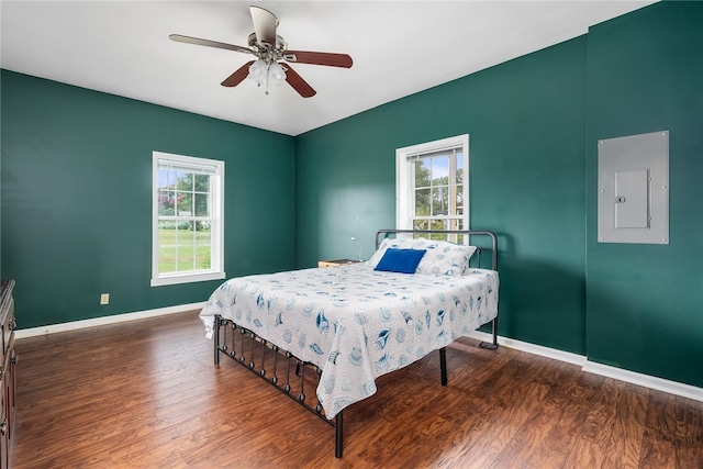 bedroom featuring electric panel, dark hardwood / wood-style floors, and ceiling fan