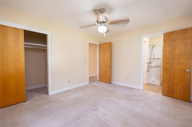 unfurnished bedroom featuring a closet, light colored carpet, ceiling fan, and ensuite bath