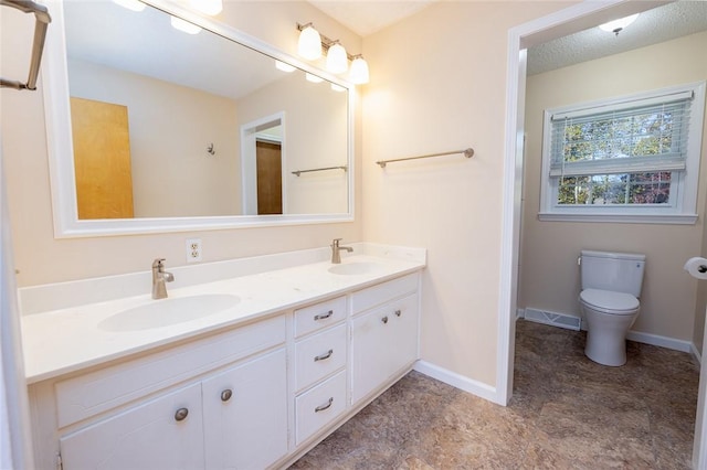 bathroom featuring a textured ceiling, toilet, and vanity