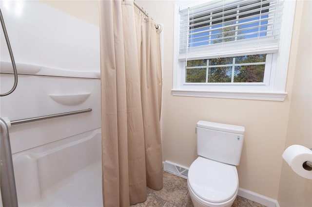 bathroom with toilet and curtained shower