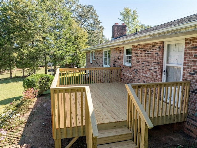 wooden deck featuring a lawn