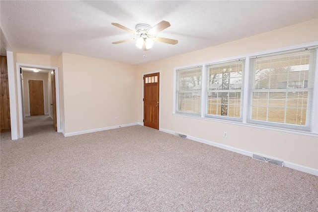 spare room with carpet, ceiling fan, and a textured ceiling