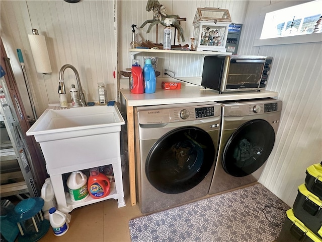 washroom featuring wood walls and separate washer and dryer