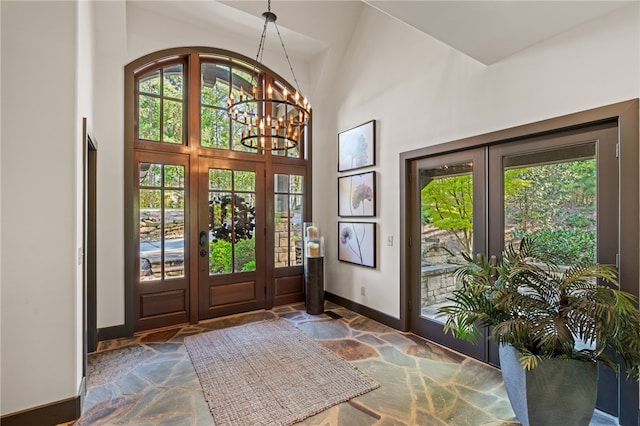 entrance foyer with an inviting chandelier, a healthy amount of sunlight, and high vaulted ceiling