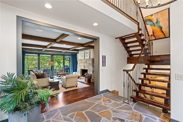 entryway with beam ceiling, coffered ceiling, wood-type flooring, and a fireplace