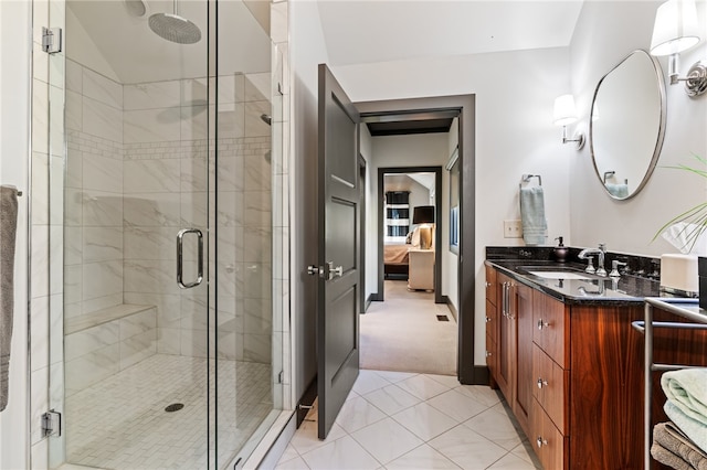 bathroom featuring vanity, walk in shower, vaulted ceiling, and tile patterned flooring