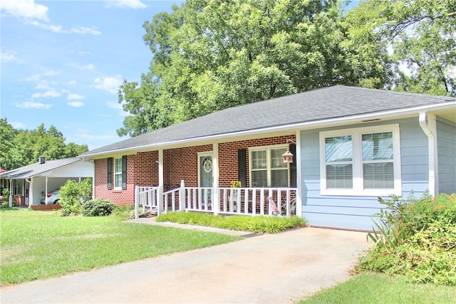 single story home with covered porch, a front yard, and a carport