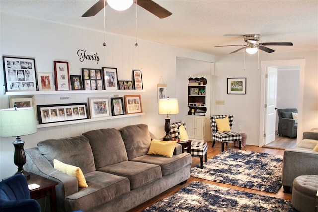 living room with ceiling fan, hardwood / wood-style flooring, and a textured ceiling