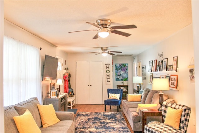 living room featuring a textured ceiling, light hardwood / wood-style floors, and ceiling fan