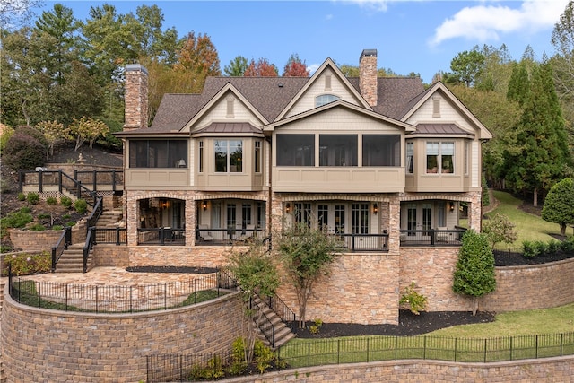 rear view of property with a sunroom and a patio area