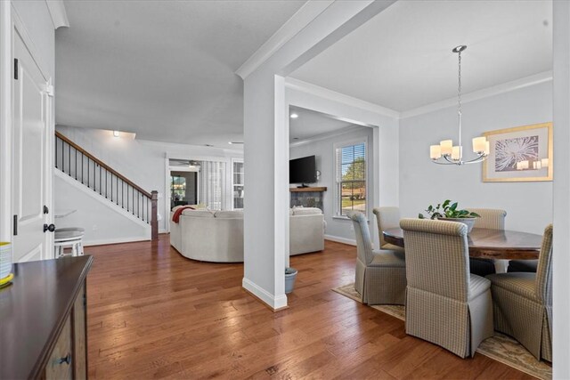 2 Winding Rock Rd, Simpsonville, SC 29680 - dining room with stairway, a chandelier, ornamental molding, wood finished floors, and baseboards