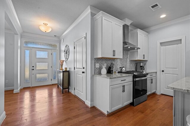 2 Winding Rock Rd, Simpsonville, SC 29680 - kitchen featuring stainless steel range with gas stovetop, wall chimney range hood, crown molding, wood finished floors, and tasteful backsplash