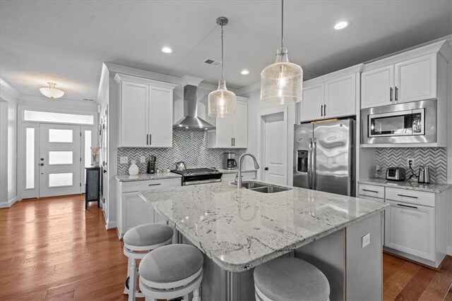 2 Winding Rock Rd, Simpsonville, SC 29680 - kitchen featuring wall chimney range hood, appliances with stainless steel finishes, a sink, decorative backsplash, and a kitchen breakfast bar