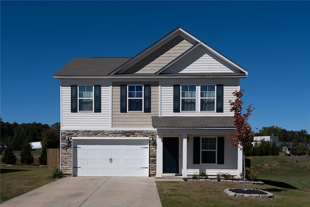 view of front of home featuring a front yard and a garage