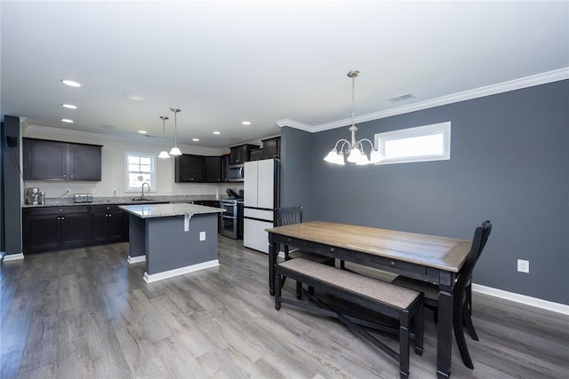 kitchen with stainless steel appliances, plenty of natural light, a notable chandelier, pendant lighting, and a center island