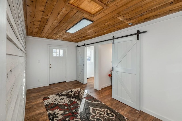 foyer featuring dark hardwood / wood-style flooring, a barn door, and wood ceiling