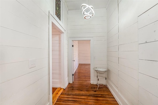 hall with dark hardwood / wood-style floors and wood walls