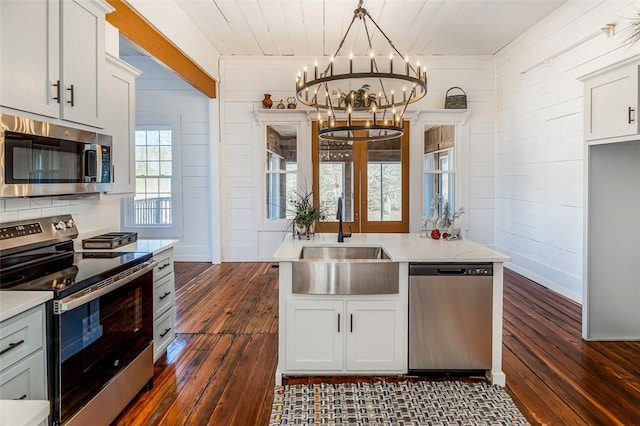 kitchen with white cabinets, sink, appliances with stainless steel finishes, and dark wood-type flooring