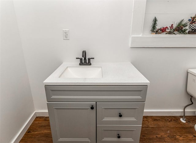 bathroom with hardwood / wood-style flooring, vanity, and toilet