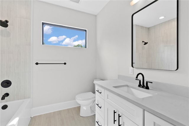 full bathroom with tiled shower / bath, vanity, hardwood / wood-style flooring, and toilet