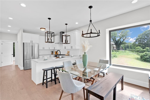 dining room with sink, light hardwood / wood-style floors, and a wealth of natural light