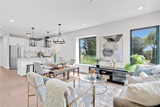 living room with sink, a healthy amount of sunlight, and light hardwood / wood-style flooring