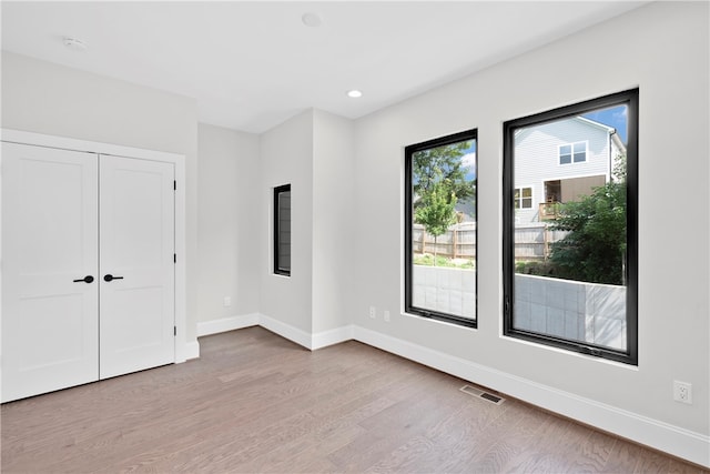 unfurnished bedroom with a closet and light hardwood / wood-style floors