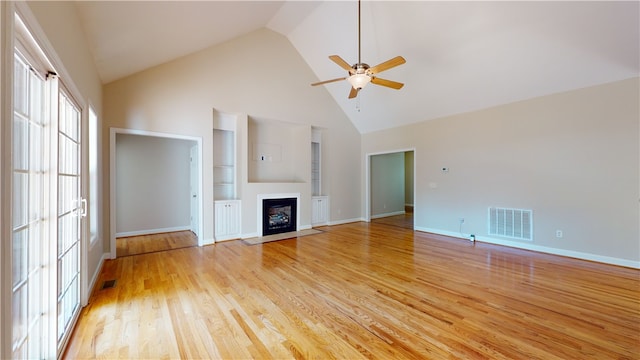 unfurnished living room featuring ceiling fan, high vaulted ceiling, light hardwood / wood-style floors, and built in shelves