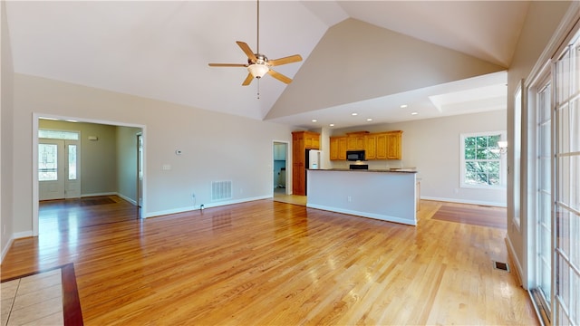 unfurnished living room featuring light hardwood / wood-style flooring, high vaulted ceiling, and ceiling fan