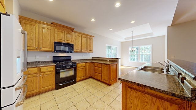 kitchen featuring sink, hanging light fixtures, a tray ceiling, kitchen peninsula, and black appliances