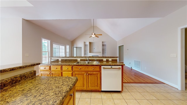 kitchen with sink, vaulted ceiling, light tile patterned floors, dishwasher, and ceiling fan