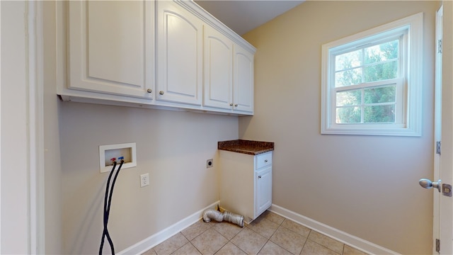 washroom with cabinets, hookup for an electric dryer, hookup for a washing machine, and light tile patterned floors