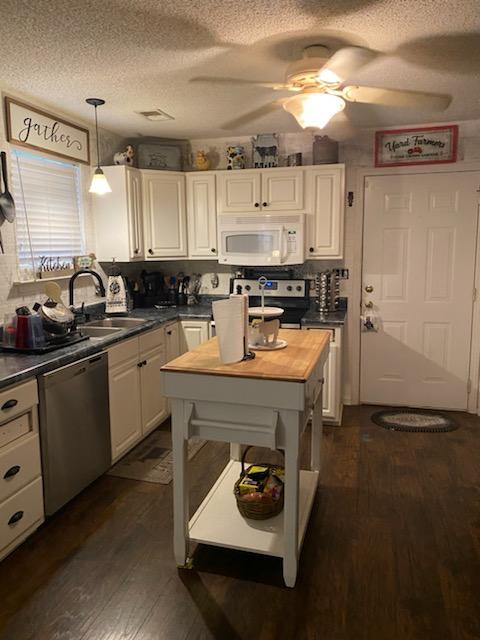 kitchen featuring sink, pendant lighting, dark wood-type flooring, and stainless steel appliances