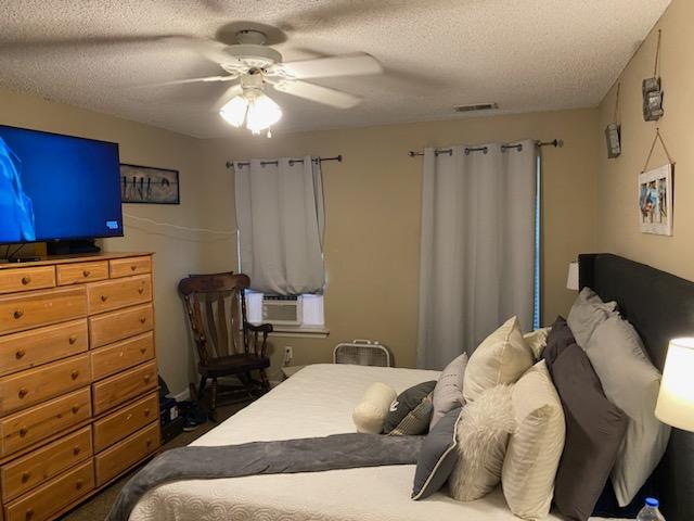 bedroom featuring ceiling fan and a textured ceiling