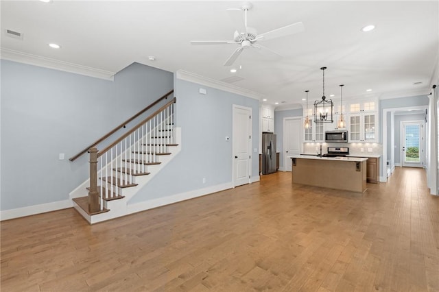 unfurnished living room with a ceiling fan, visible vents, light wood-style floors, ornamental molding, and recessed lighting