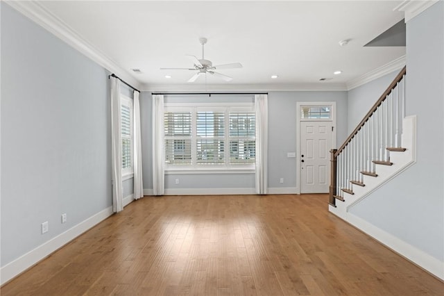 foyer with crown molding, ceiling fan, stairs, baseboards, and wood finished floors