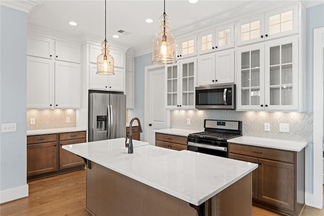 kitchen featuring white cabinets, hanging light fixtures, appliances with stainless steel finishes, light wood-style floors, and visible vents