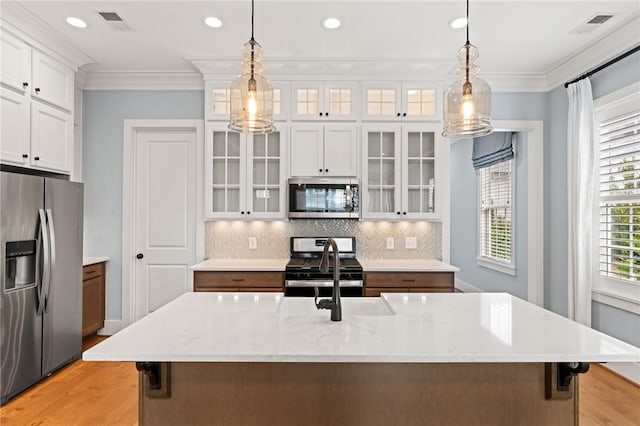 kitchen featuring crown molding, light wood-style flooring, appliances with stainless steel finishes, and visible vents