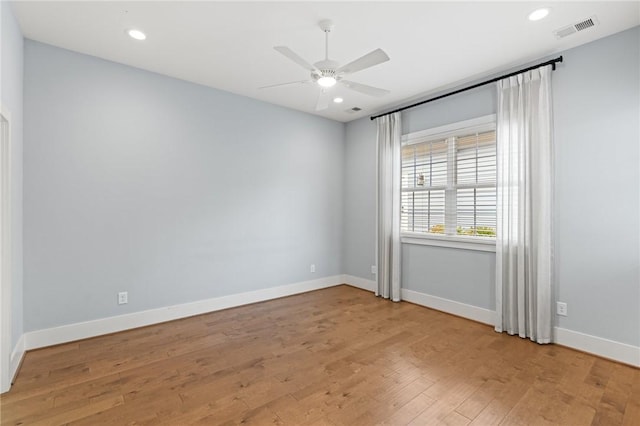 spare room with ceiling fan, visible vents, baseboards, and light wood-style flooring