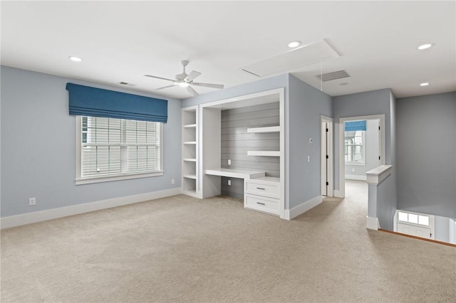 interior space featuring baseboards, attic access, and light carpet