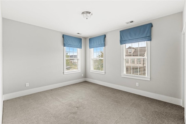 carpeted empty room with visible vents and baseboards