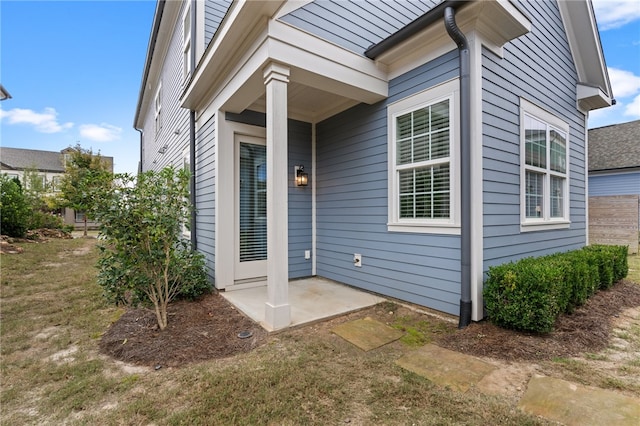 view of exterior entry featuring a lawn