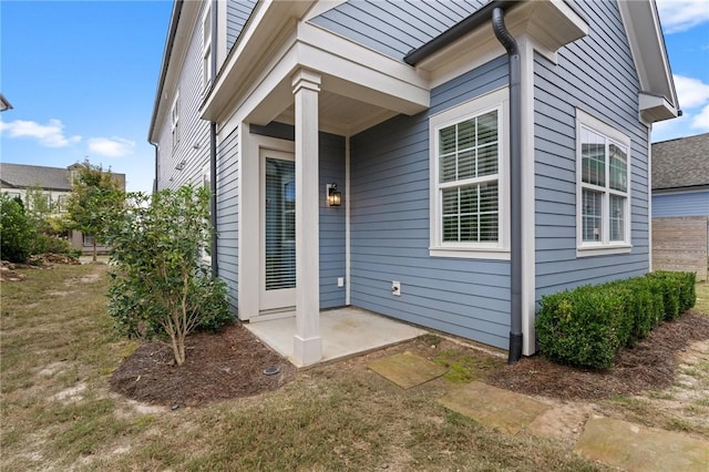 doorway to property with a yard and a patio