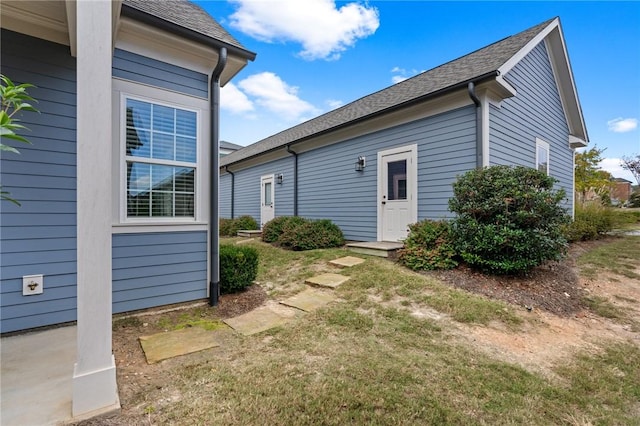 rear view of property featuring roof with shingles
