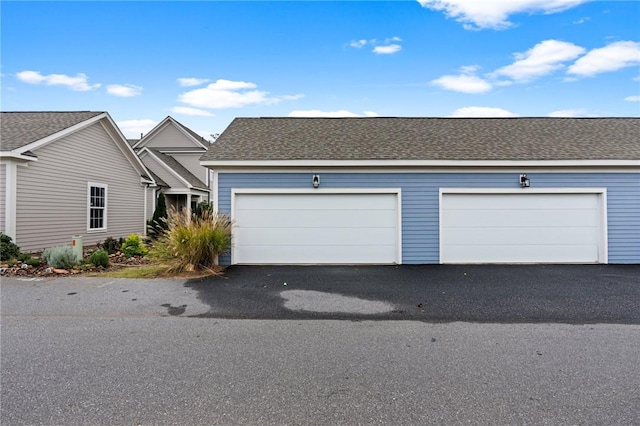 view of front of home with a shingled roof and driveway