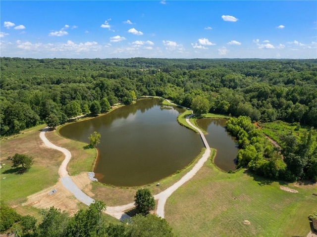 birds eye view of property featuring a water view and a wooded view