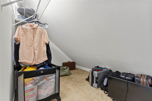 spacious closet with vaulted ceiling and light colored carpet