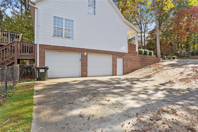 view of home's exterior with a wooden deck and a garage