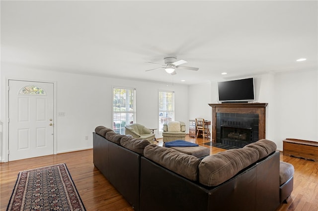 living room with hardwood / wood-style flooring, a tile fireplace, and ceiling fan